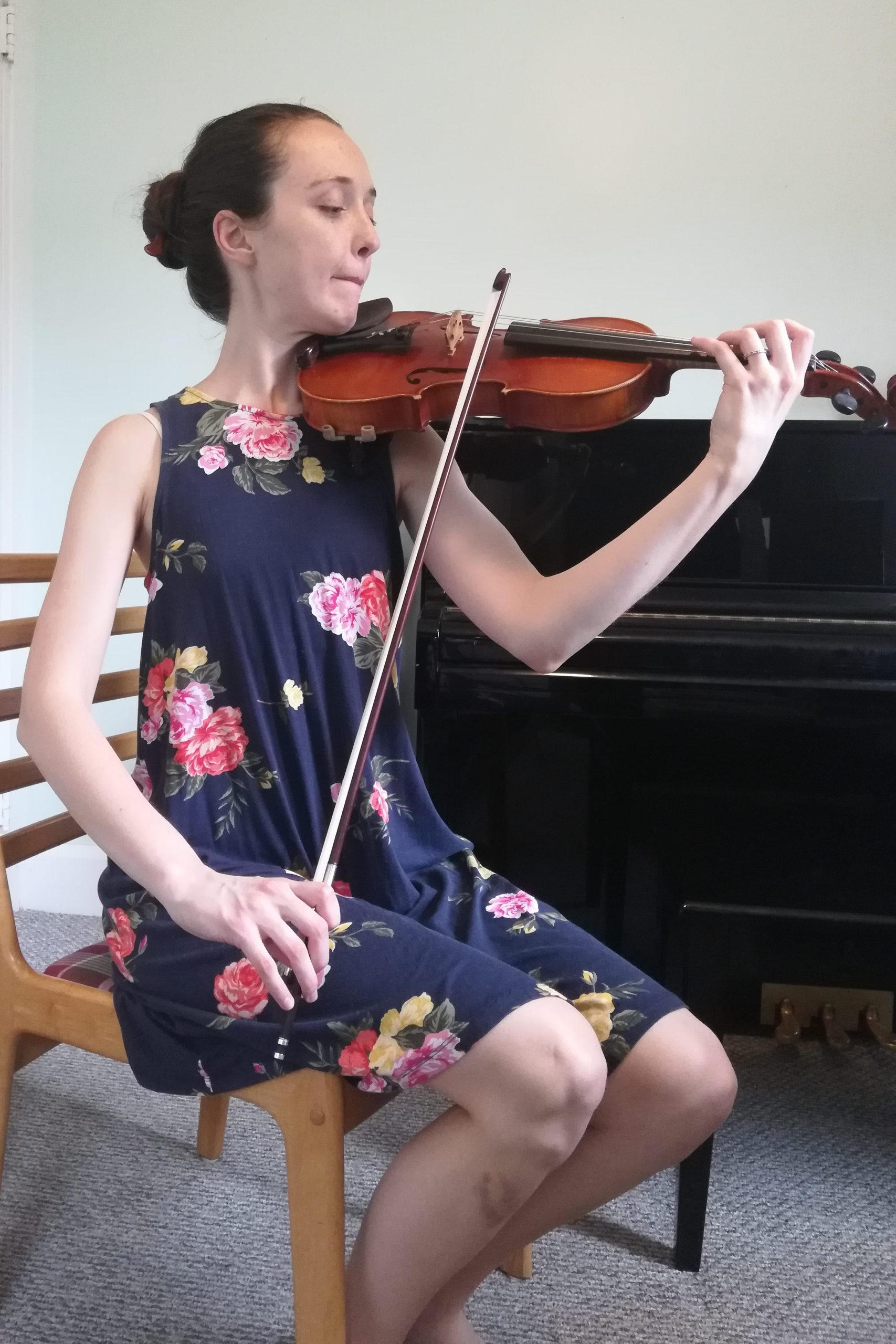 me sitting and playing violin with bow passing to right of thighs
