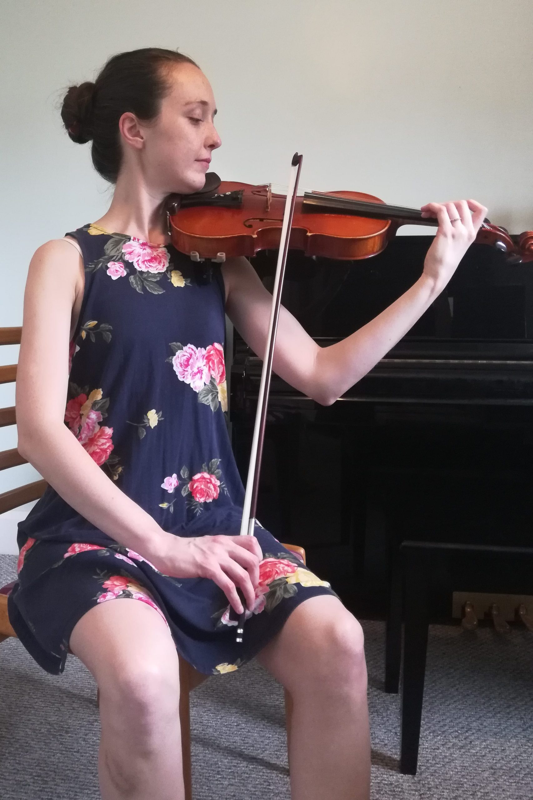 me sitting and playing violin with bow passing between legs