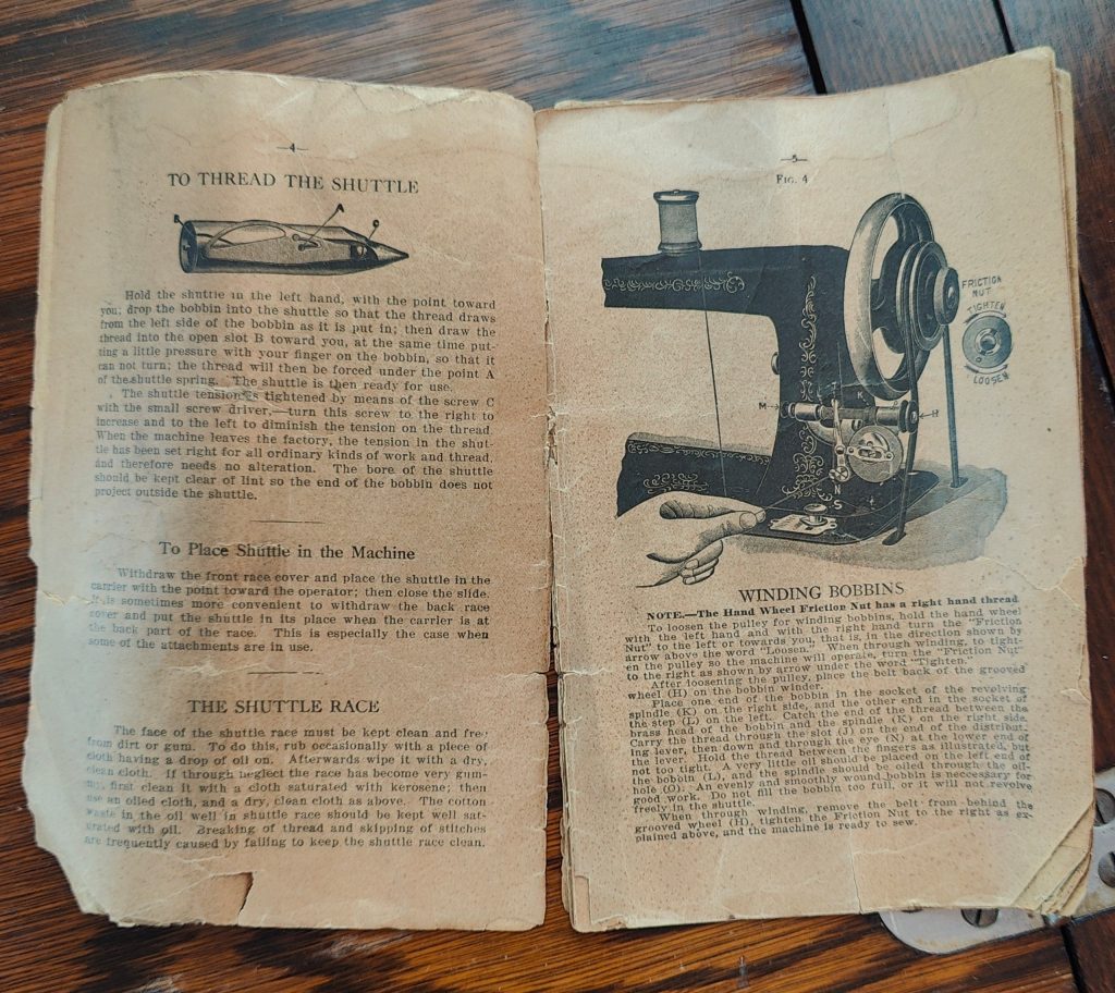 antique sewing machine instruction manual open to threading instructions